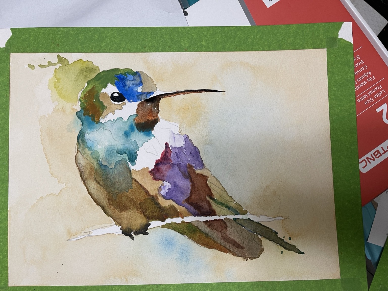 Hummingbird watercolor in progress with blue, turquoise, violet, and brown washes, a painted eye, and a long beak